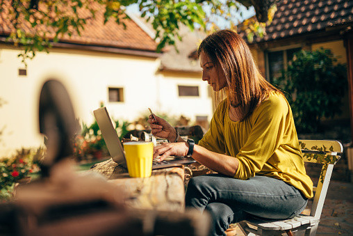 Backyard Credit Card
 Women Using Credit Card At Backyard Patio Stock