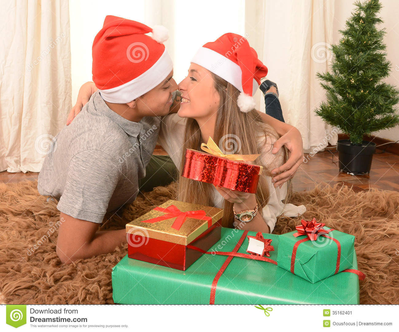 Christmas Gift Ideas Young Couple
 Young Happy Couple Kissing Rug At Christmas Stock Image